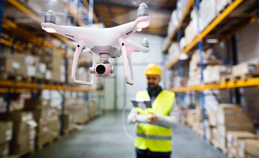An image of a warehouse employee operating a warehouse drone