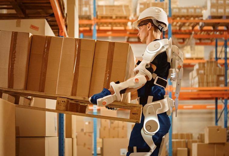 A warehouse operator equipped with wearables while carrying inventory