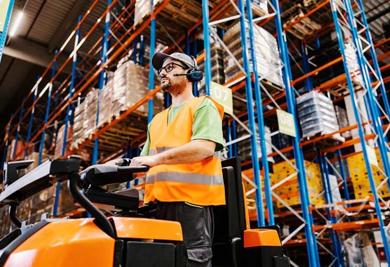 A male warehouse employee wearing a voice-picking headset​