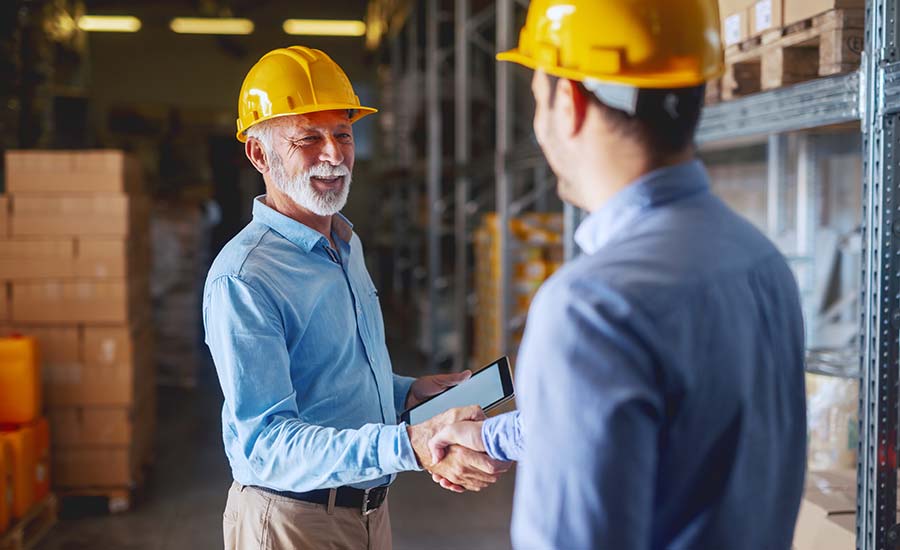 A warehouse manager shaking hands with a business partner​
