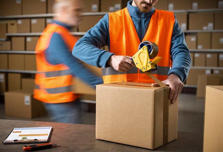 Two warehouse employees working​