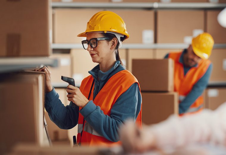 A female warehouse employee scanning a box in a warehouse​