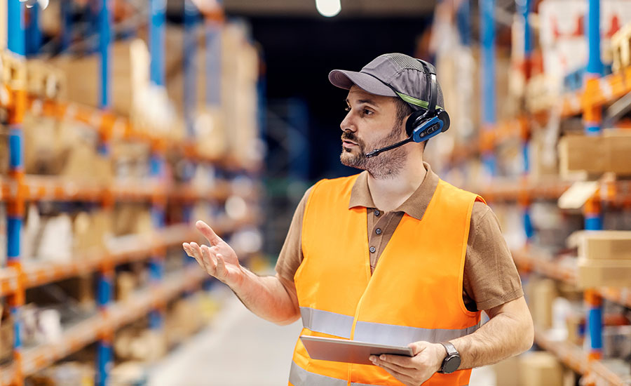 A male warehouse employee wearing a voice-picking headset​