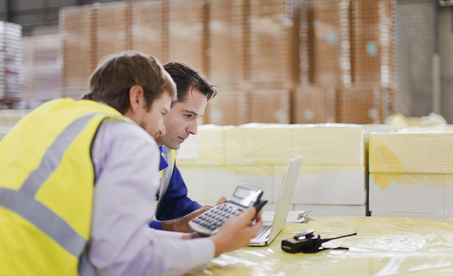 Two warehouse employees holding a calculator​