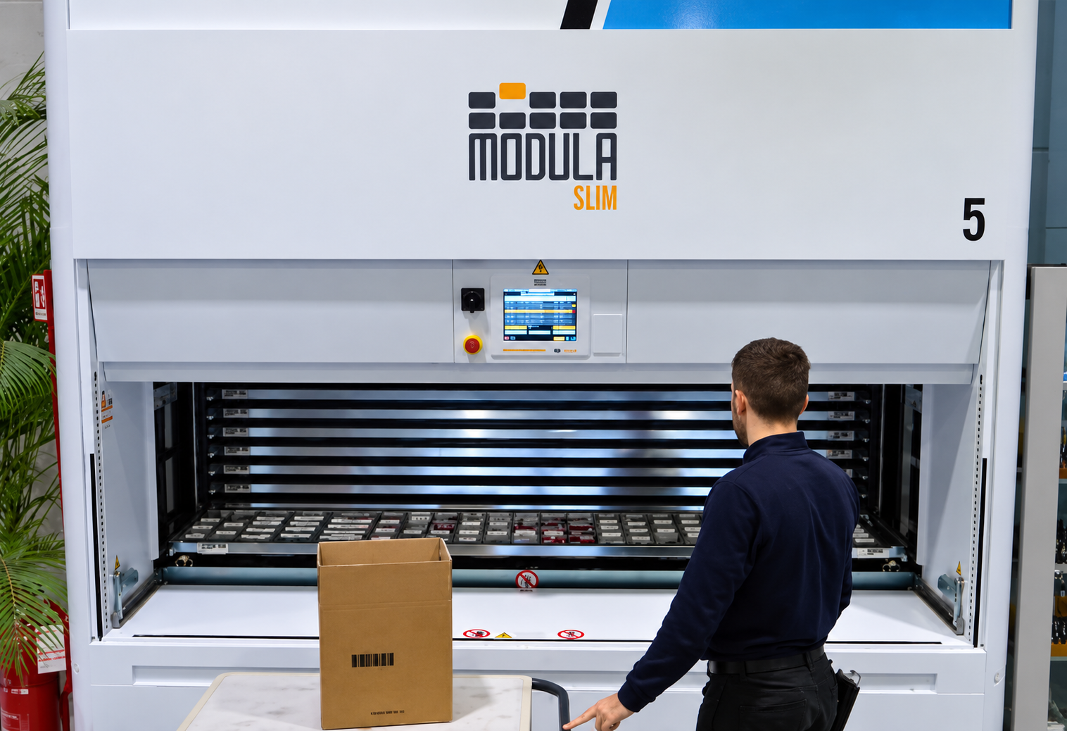 New Fer employee operating a Modula Slim vertical lift module used to store and retrieve hardware and industrial supplies.